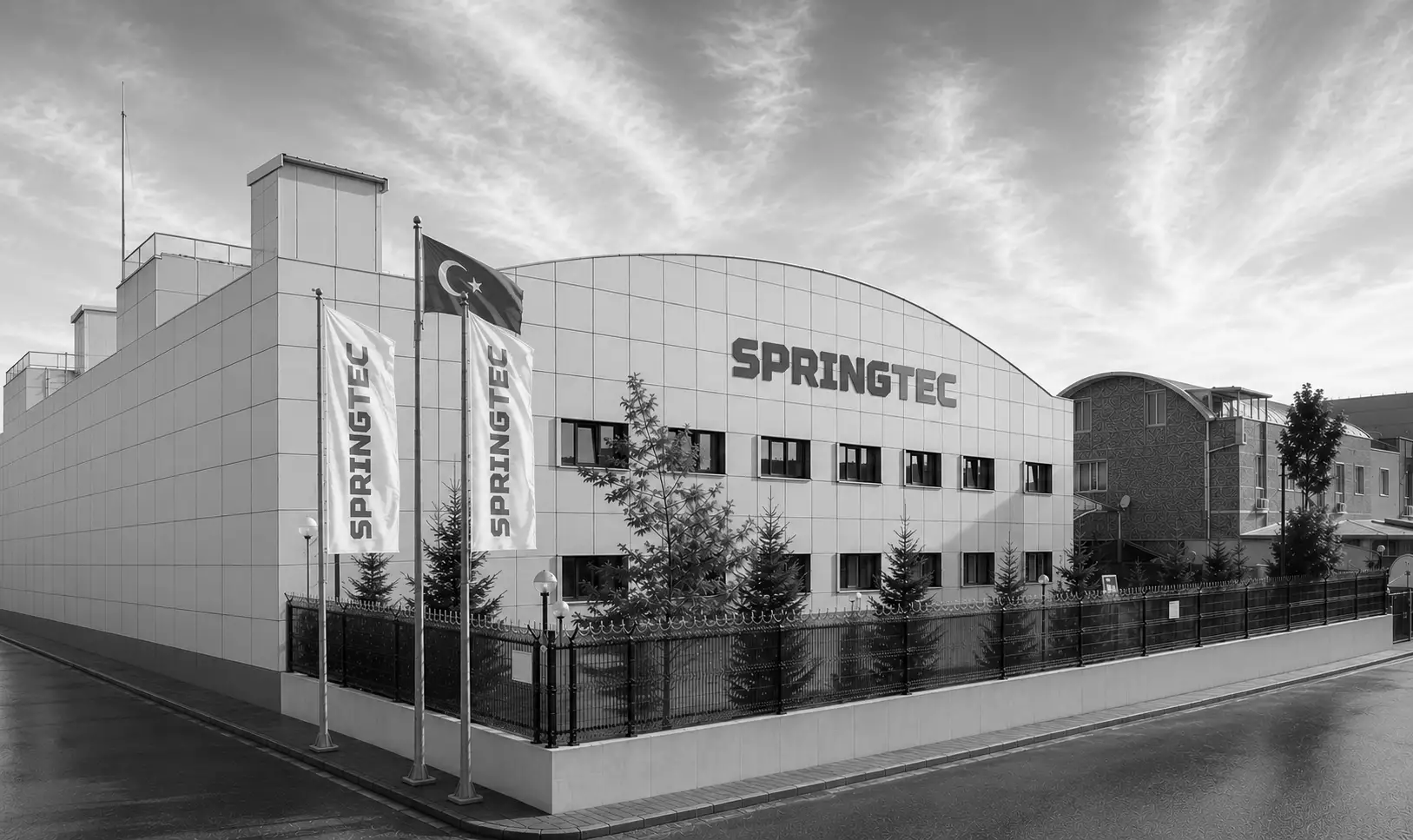 Modernes Firmengebäude von SPRINGTEC mit Flaggen